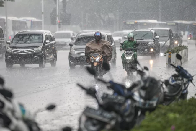 
 pengendara motor dan mobil ditengah hujan deras jakarta